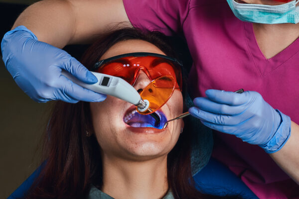 Female dentist treating a patient. Close-up photo of a young woman sitting in the dentist's chair.